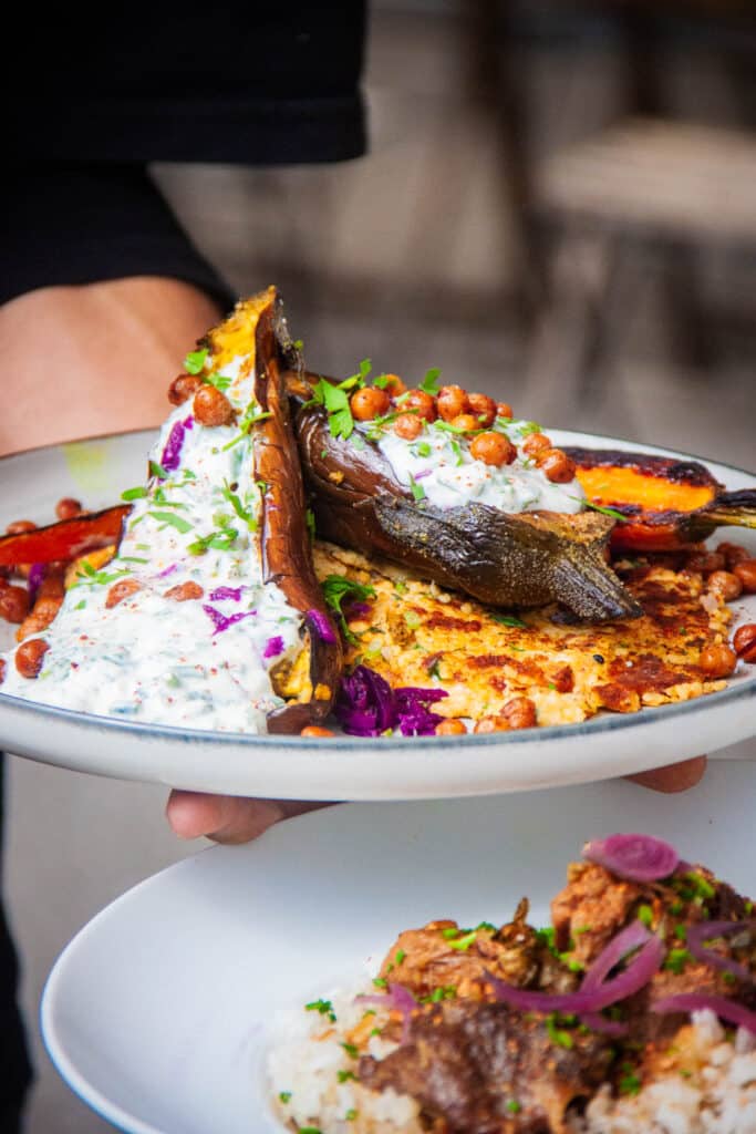 Aubergines rôties servies avec sa sauce yaourt et ses pois chiches. plat végétarien servi à la guinguette de Tours, le restaurant "la petite embarque"